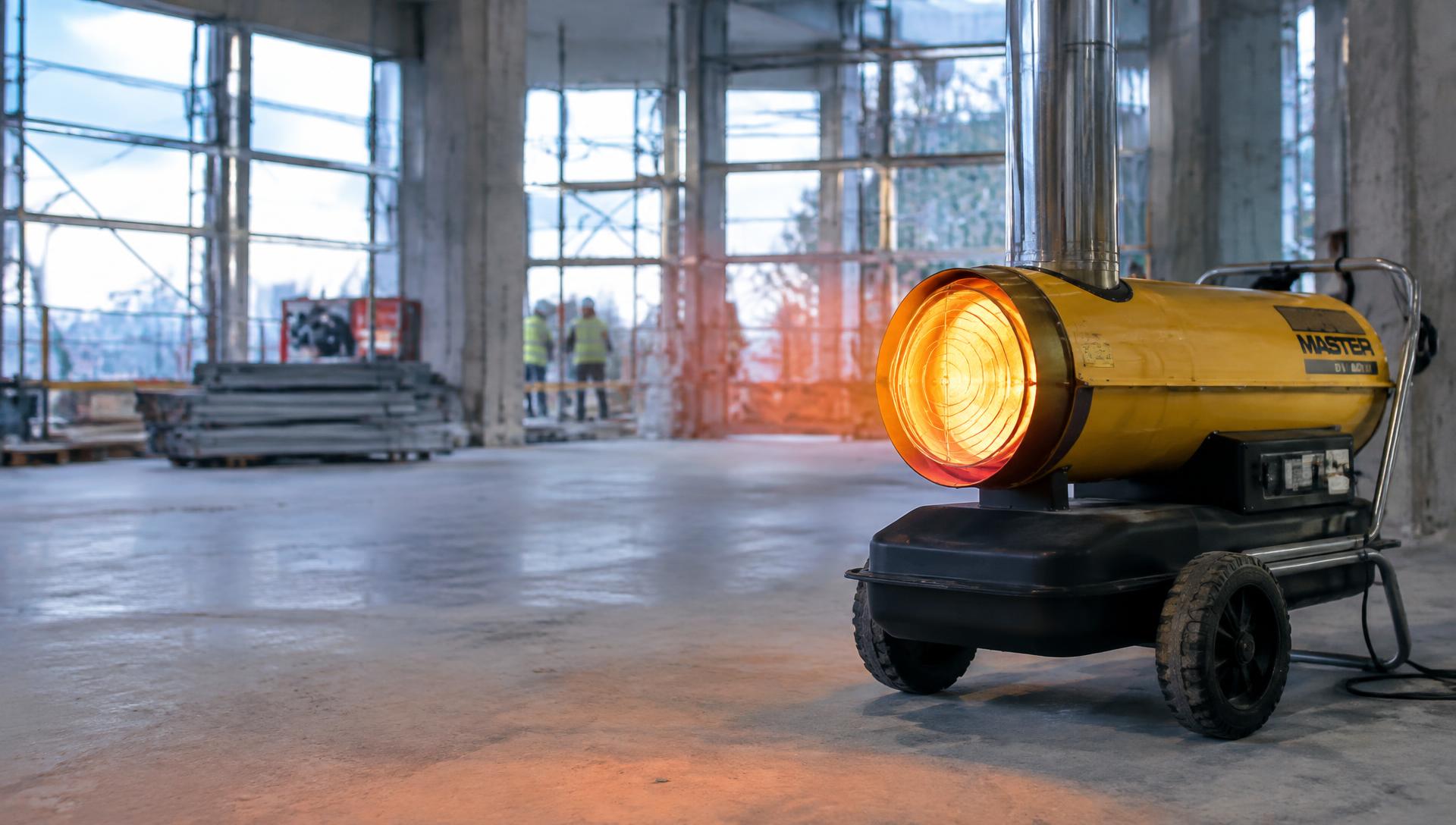 Portable oil fired space heater warming a building site